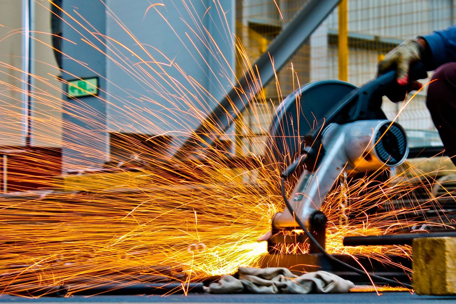 Industrial metal fabrication sparks during cutting and finishing of commercial steel parts